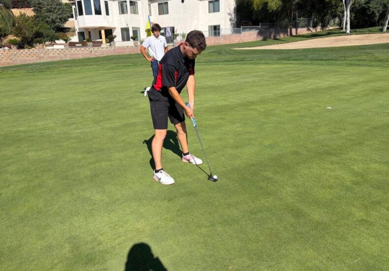 Agundez setting up to address the ball, on a golf course